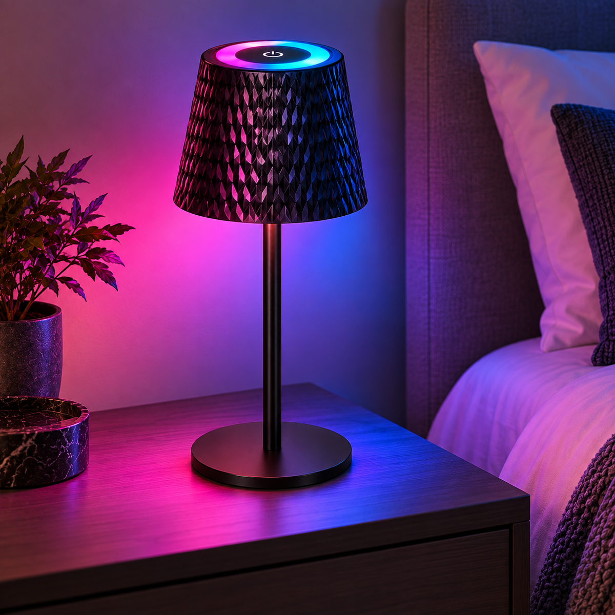 Lampă de masă RGB neagră, aprinsă în nuanțe roz și albastru pe noptieră