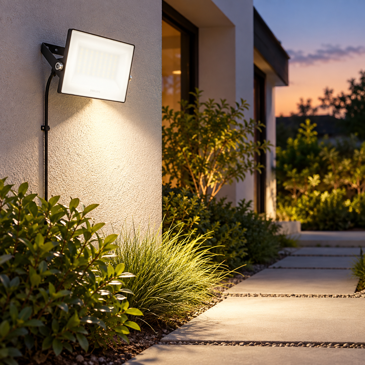Proiector LED Philips montat pe exteriorul casei, iluminând aleea